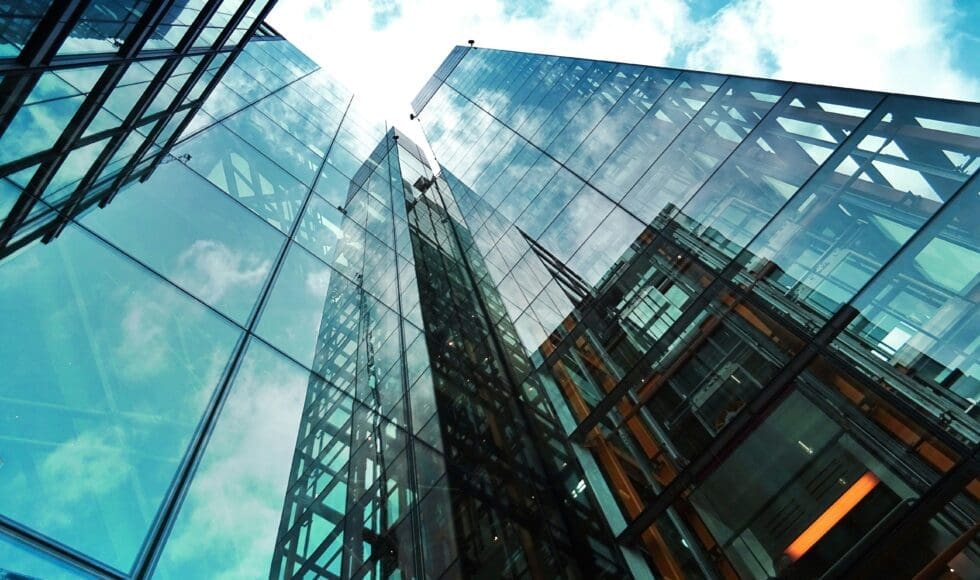 Glass skyscraper reflecting the sky on a sunny day.